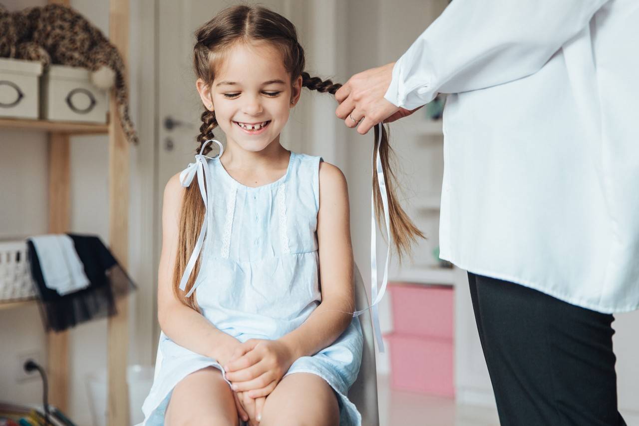 mãe fazendo um penteado com fitinhas para filha usar na festa junina