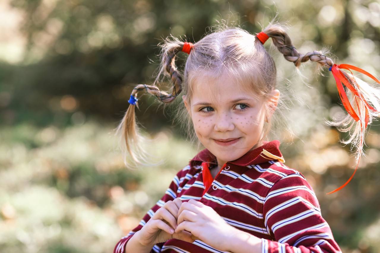 menina pronta para festa junina com tranças cheias de fitas