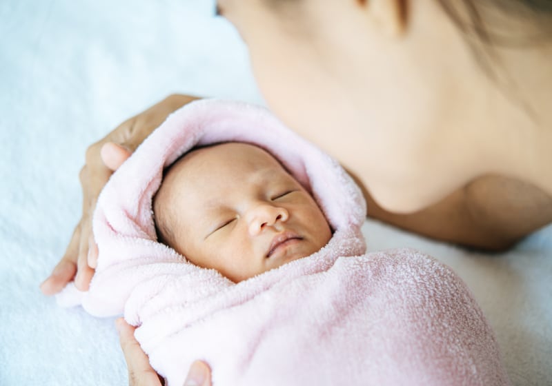 imagem de mulher colocando bebe para dormi