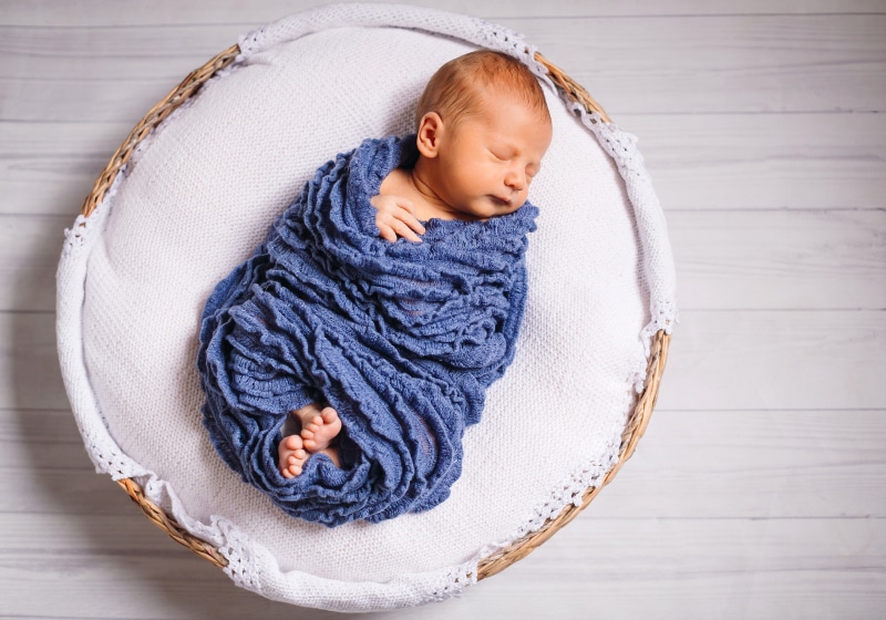 bebe rescém nascido dormindo em um cesto