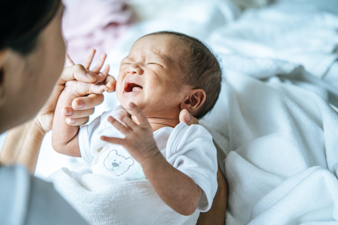 bebê recém nascido chorando no colo da mãe