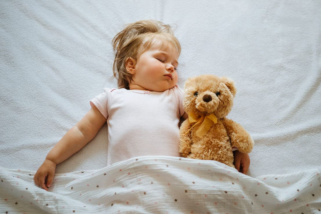 menina dormindo na cama com música de ninar