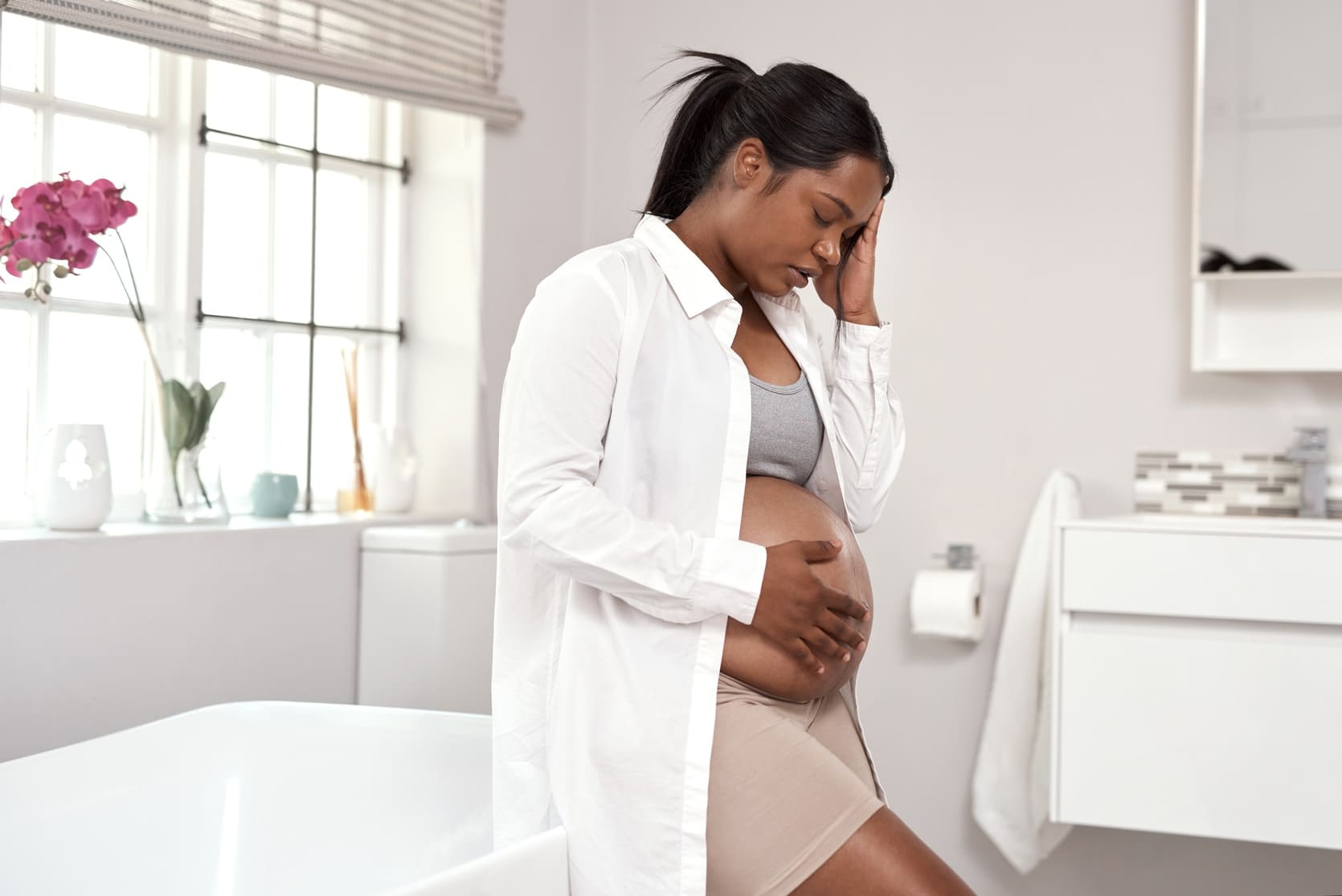 mulher grávida cansada no banheiro