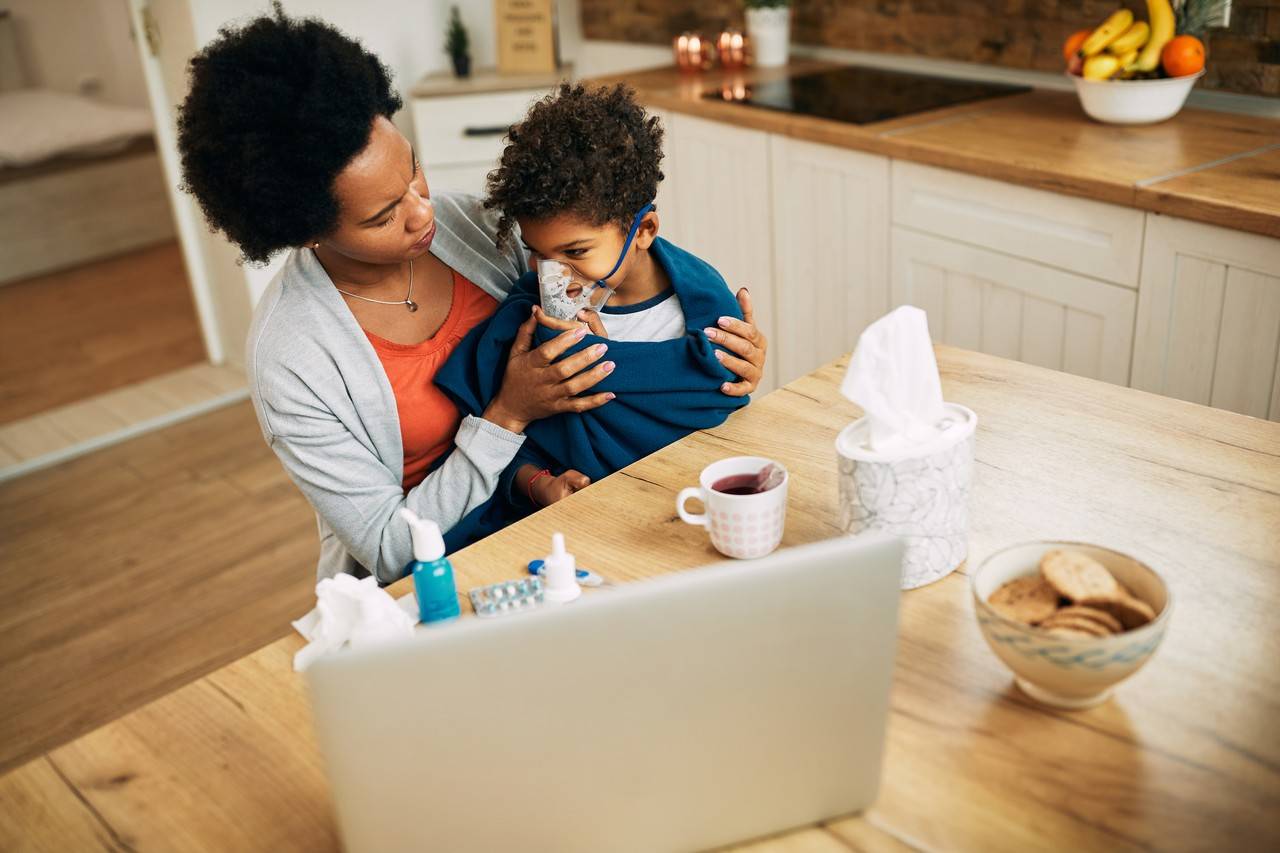 mãe ajudando o filho a fazer inalação para melhorar a bronquite