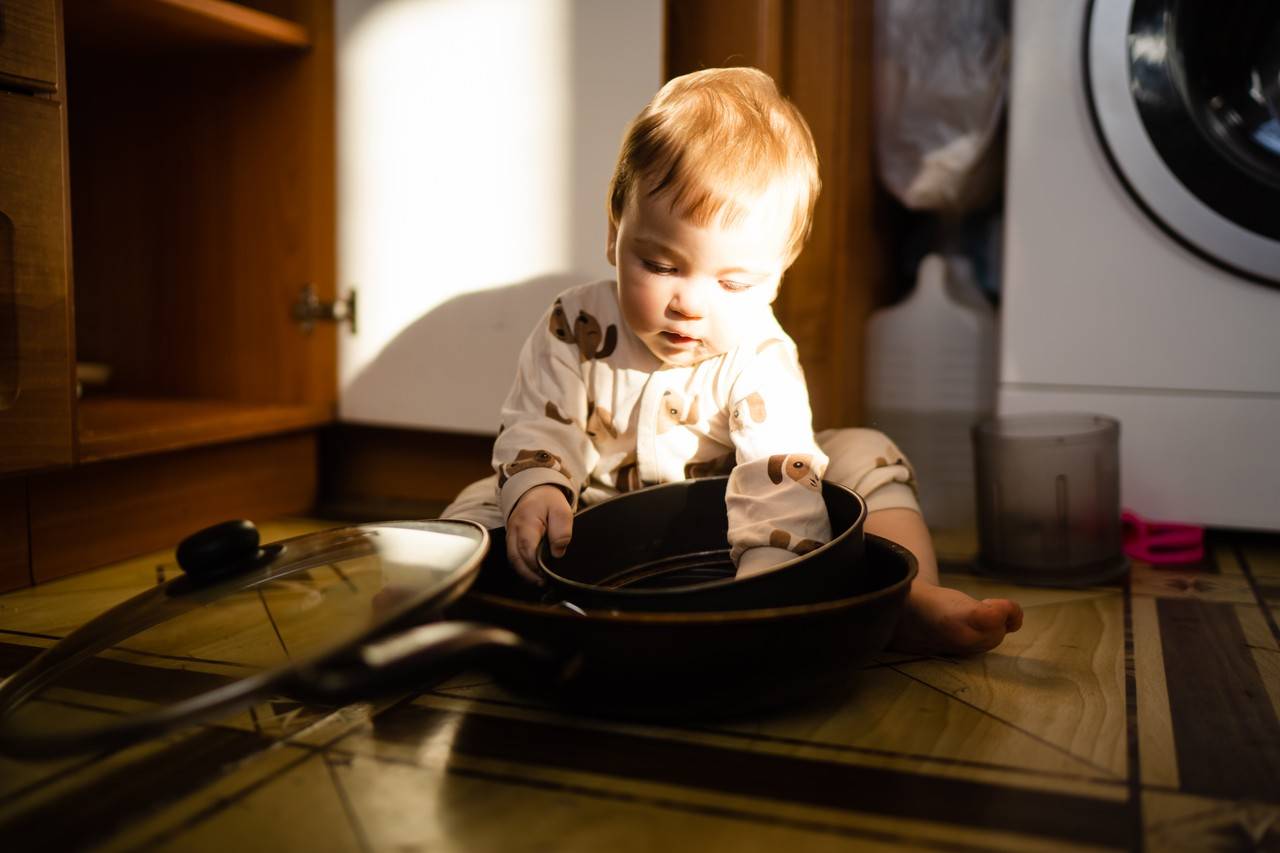 bebê brincando com panelas na cozinha