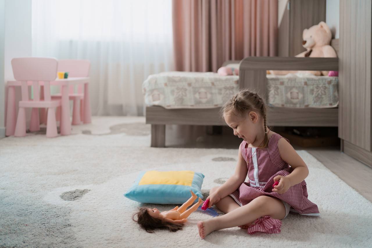 menina brincando no tapete do quarto em segurança