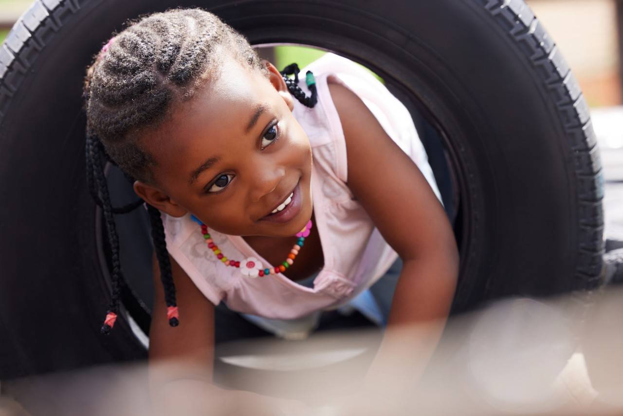 menina chamada Josiane brincando com um pneu de carro