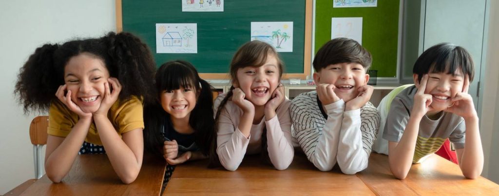 crianças sorrindo e fazendo pose na sala de aula