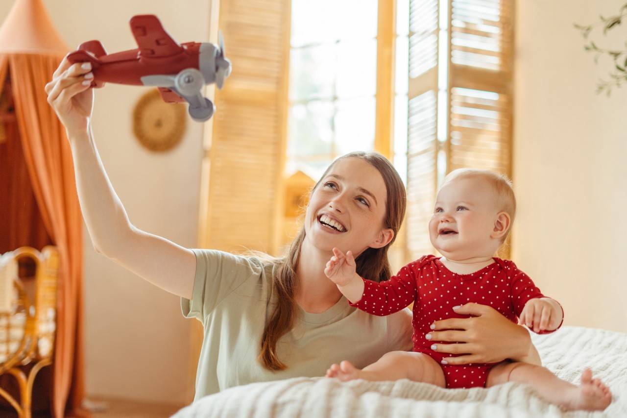 mãe com filho brincando de avião