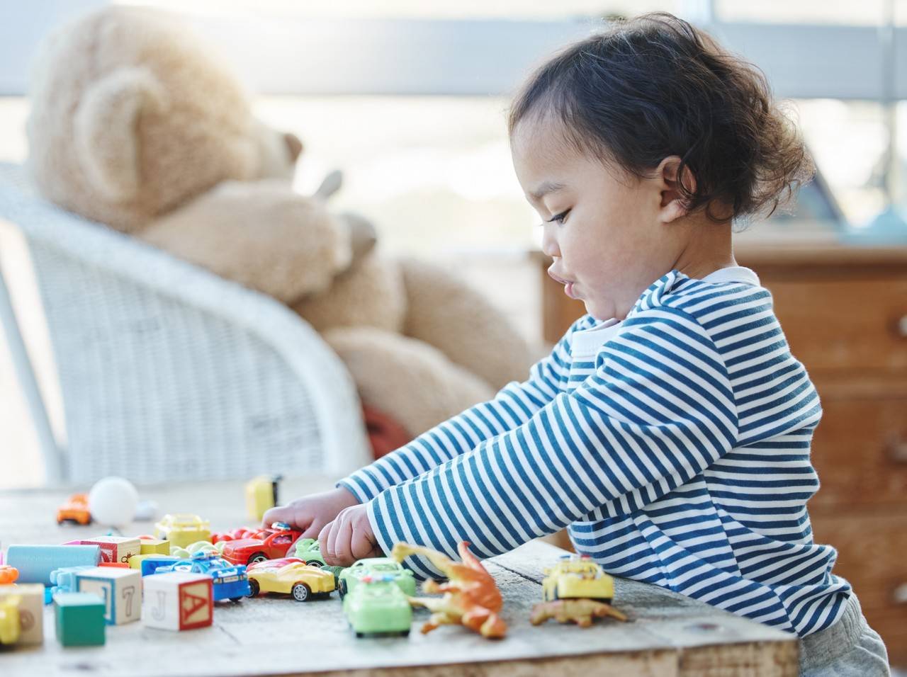 menina de dois anos brincando com carrinho