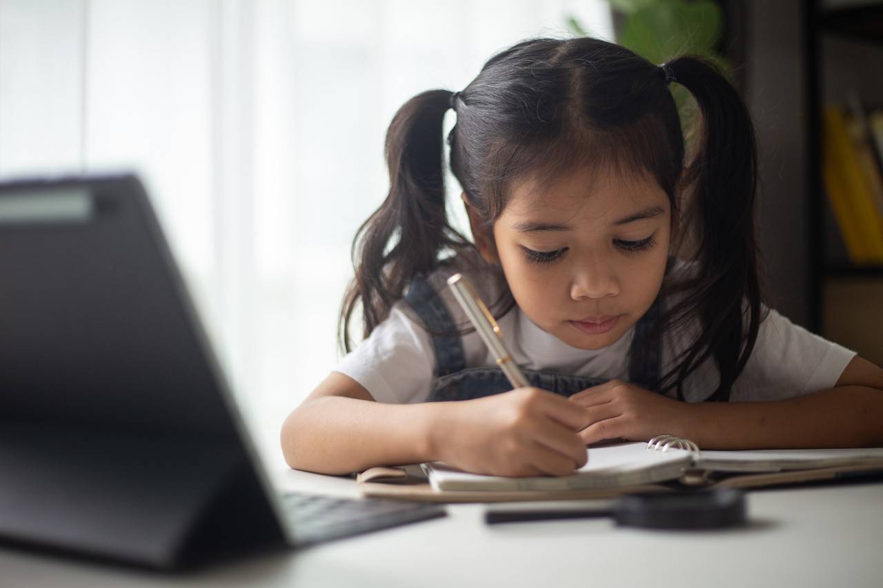 menina asiatica estudando com laptop