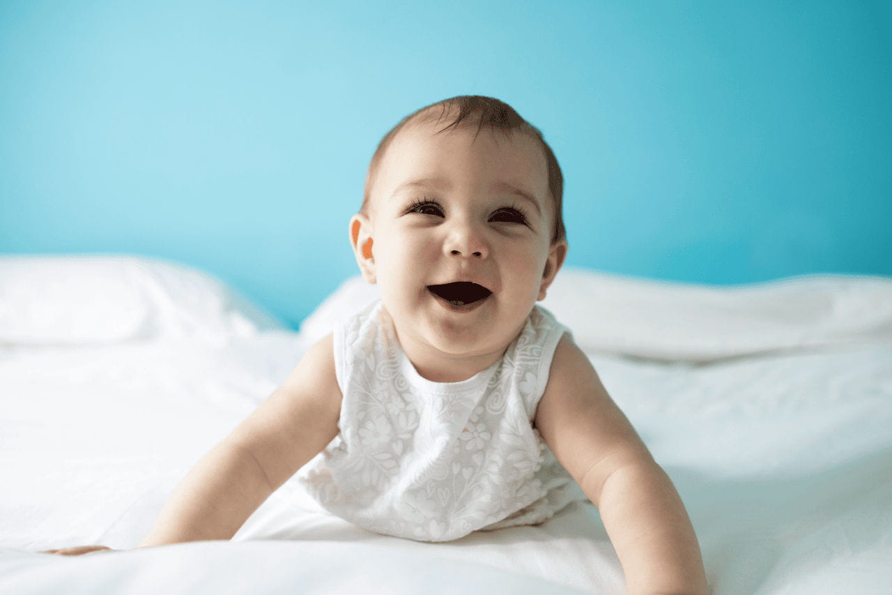 bebê em cama sorrindo