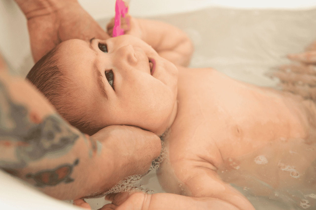 mãe segurando filho dentro de banheira