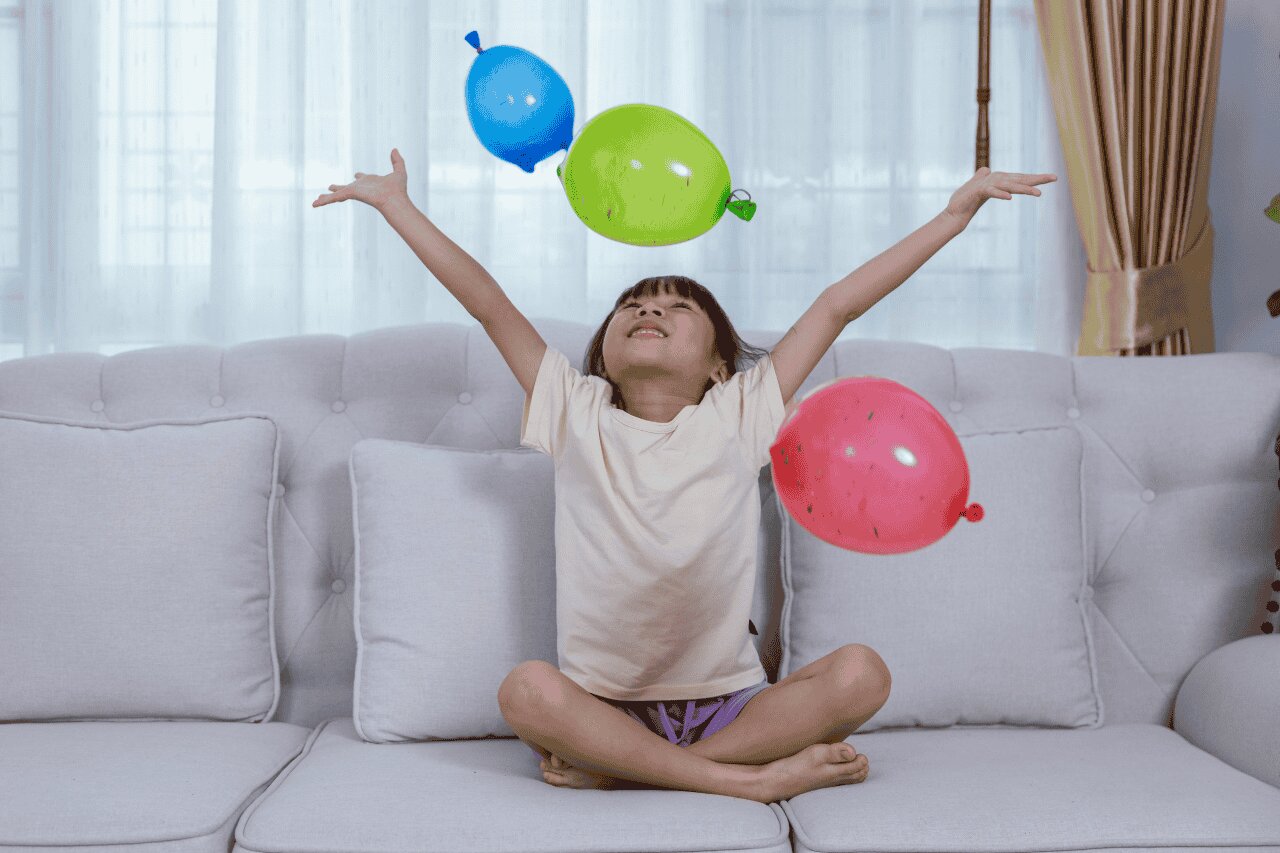 Criança feliz brincando com balões coloridos