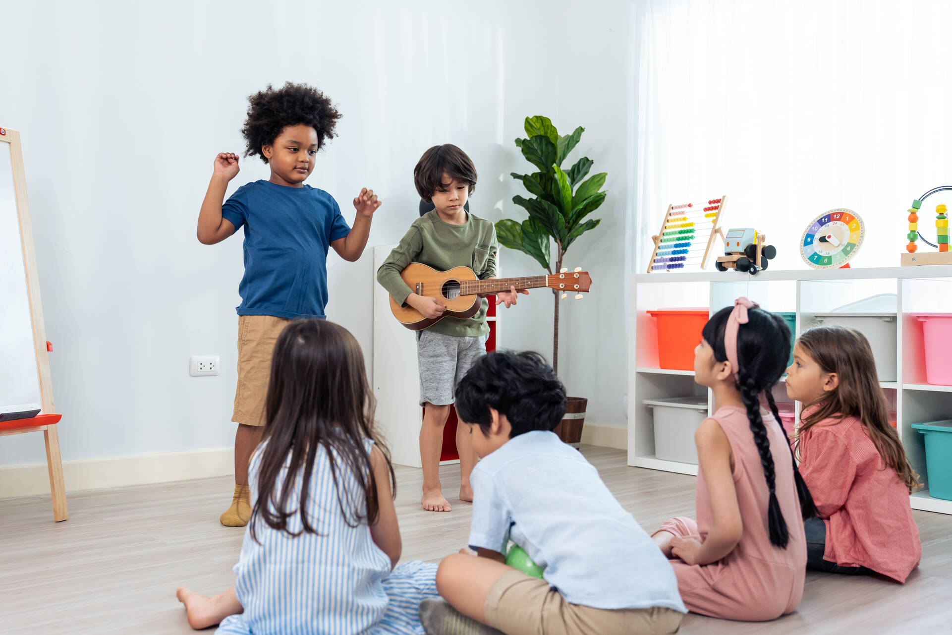Crianças em aula cantando e tocando violão