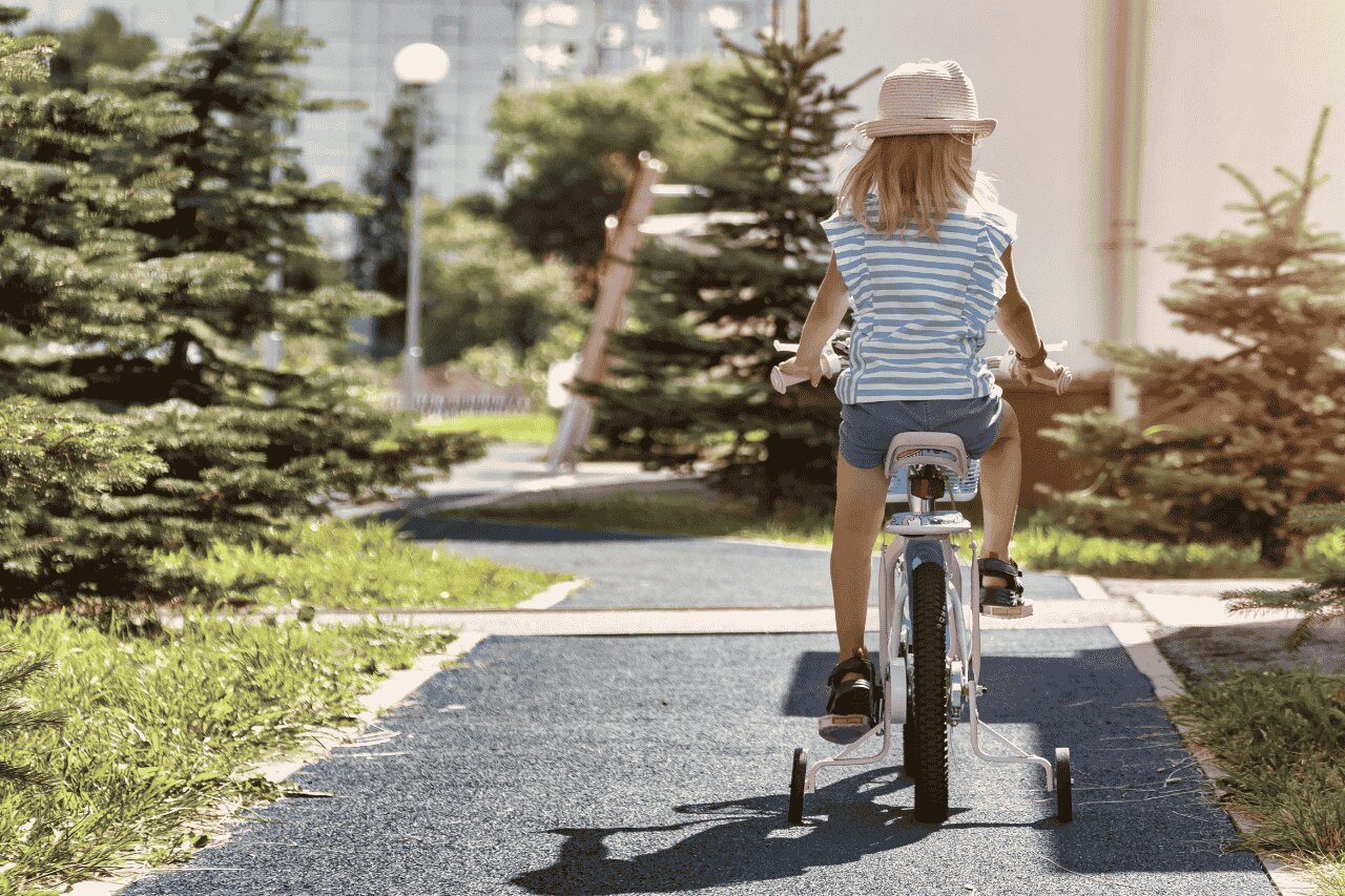 Criança andando de bicicleta em parque ao ar livre