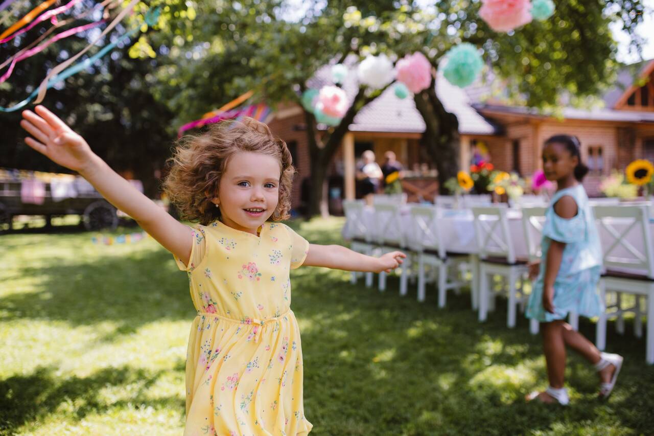 Criança brincando em festa ao ar livre com flores decorativas