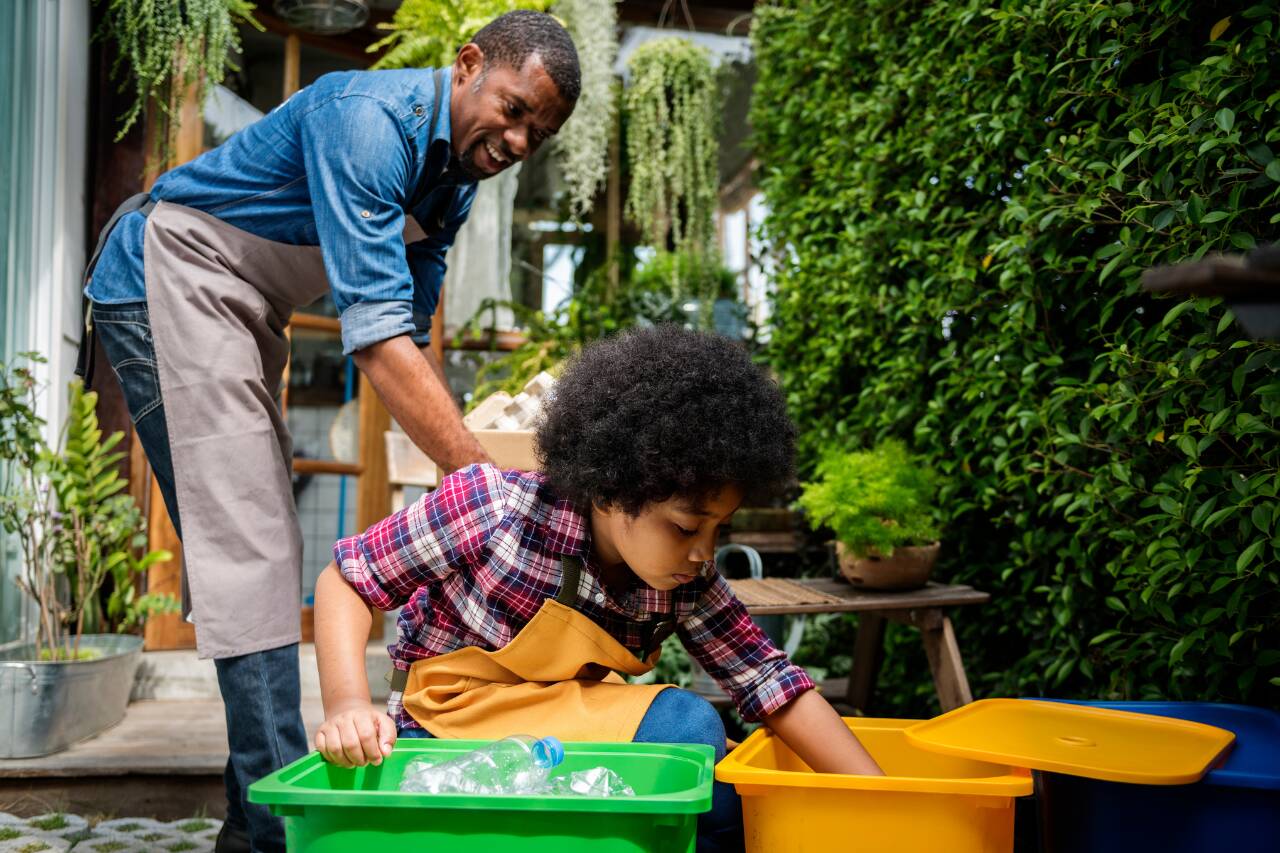 Homem e criança organizando reciclagem no jardim