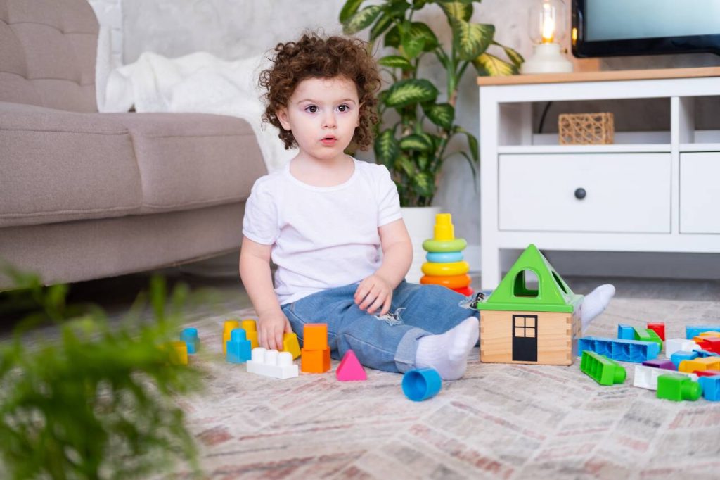 Criança brincando com blocos coloridos no chão