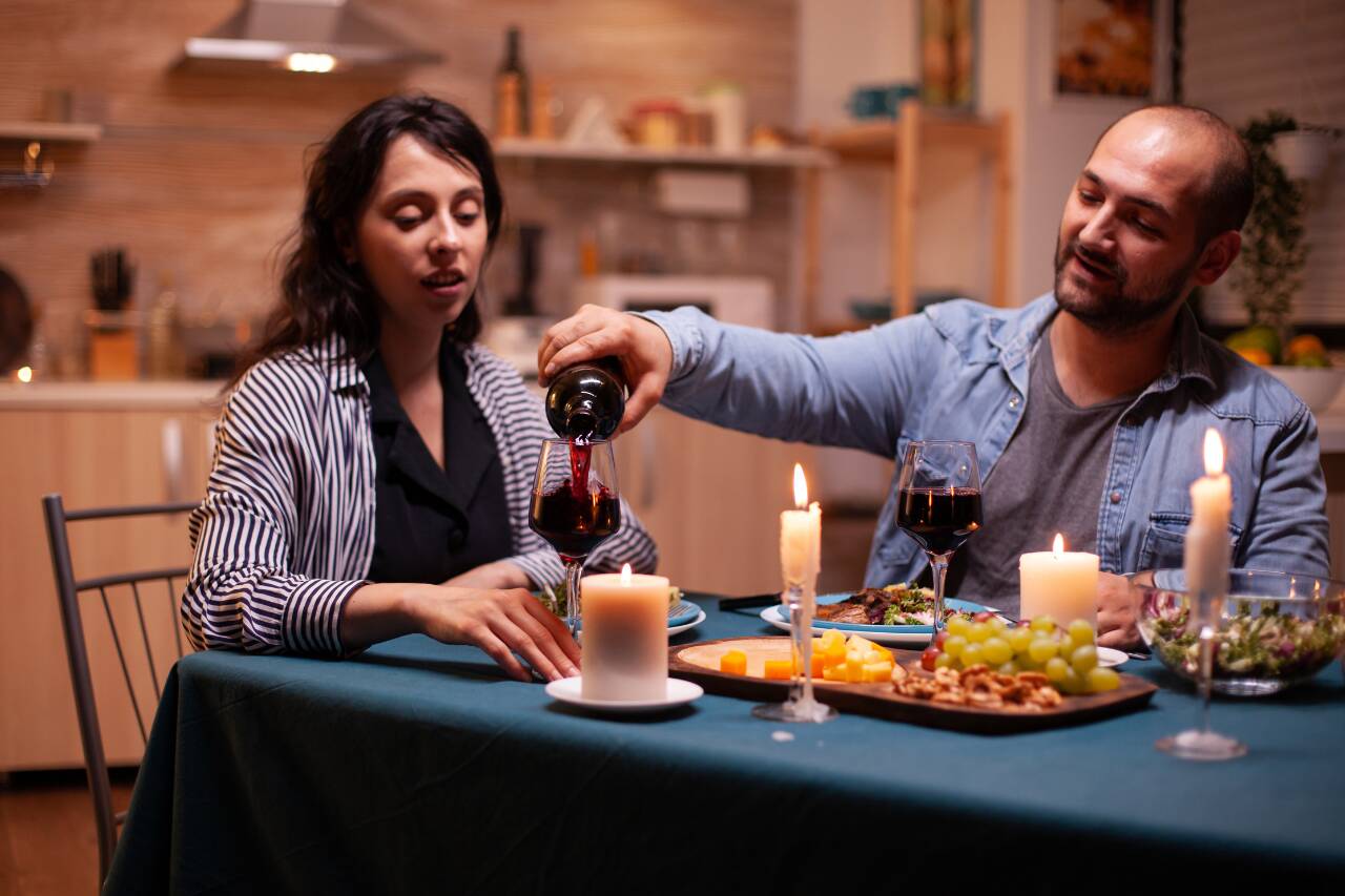 Casal desfrutando jantar à luz de velas em casa
