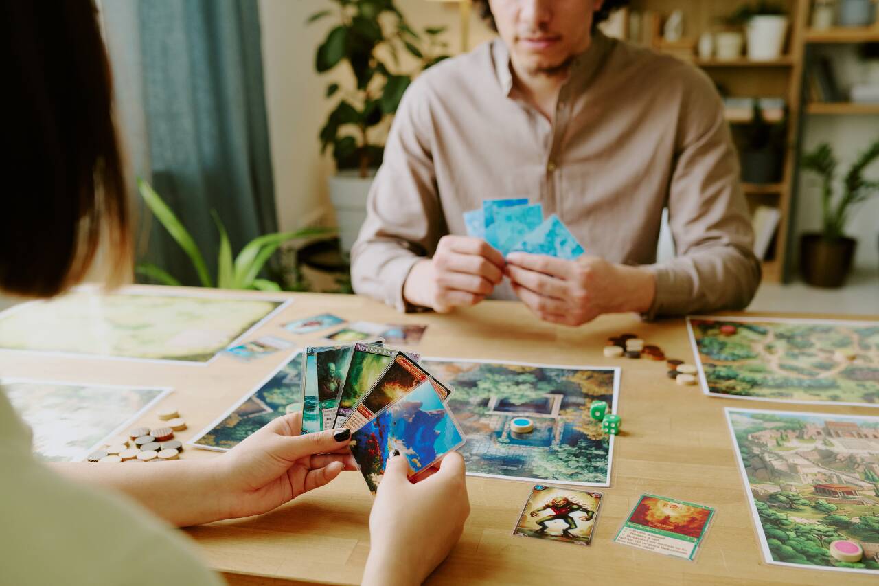 Pessoas jogando um jogo de tabuleiro em mesa.