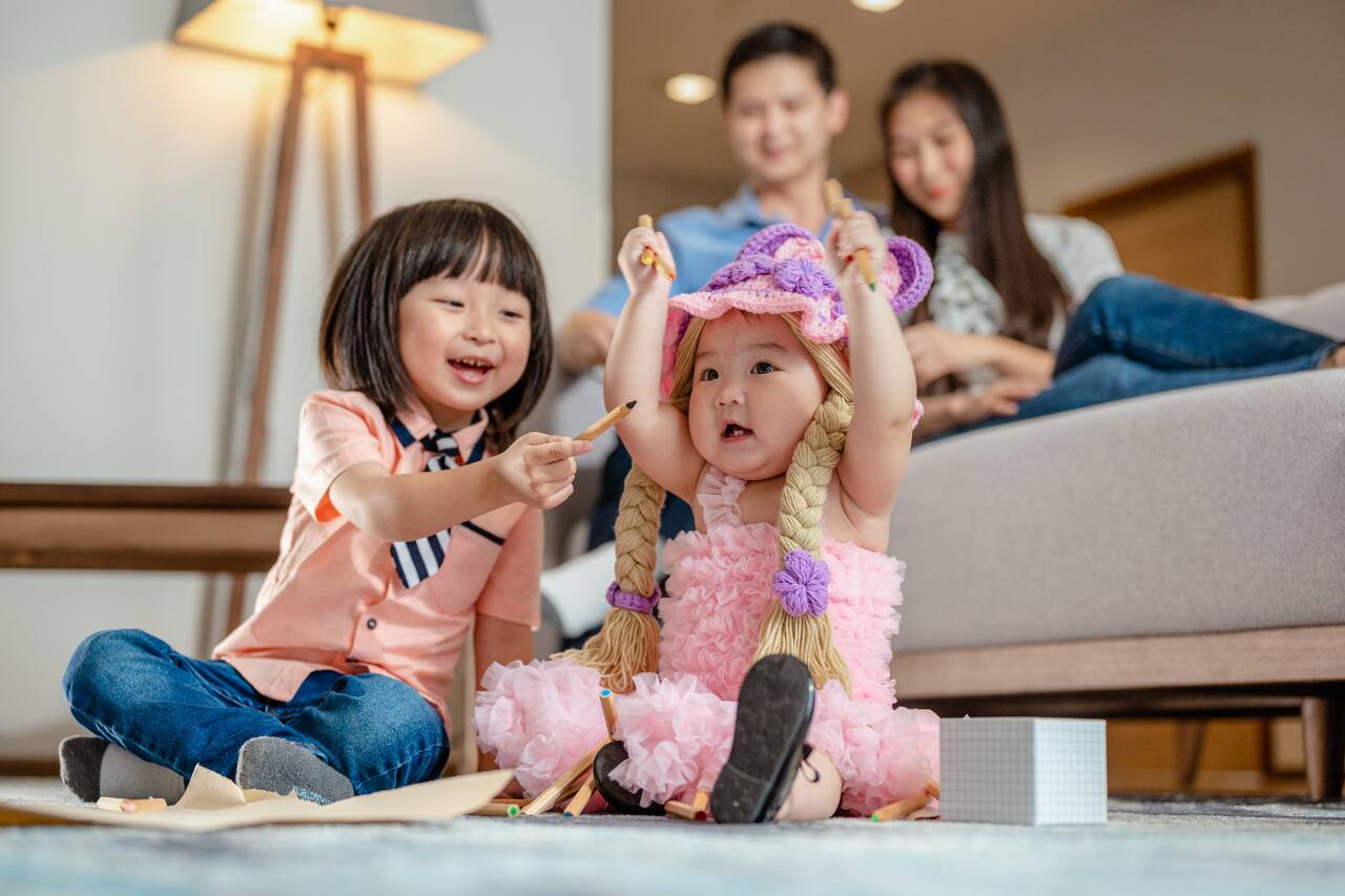 Crianças brincando em casa com lápis coloridos
