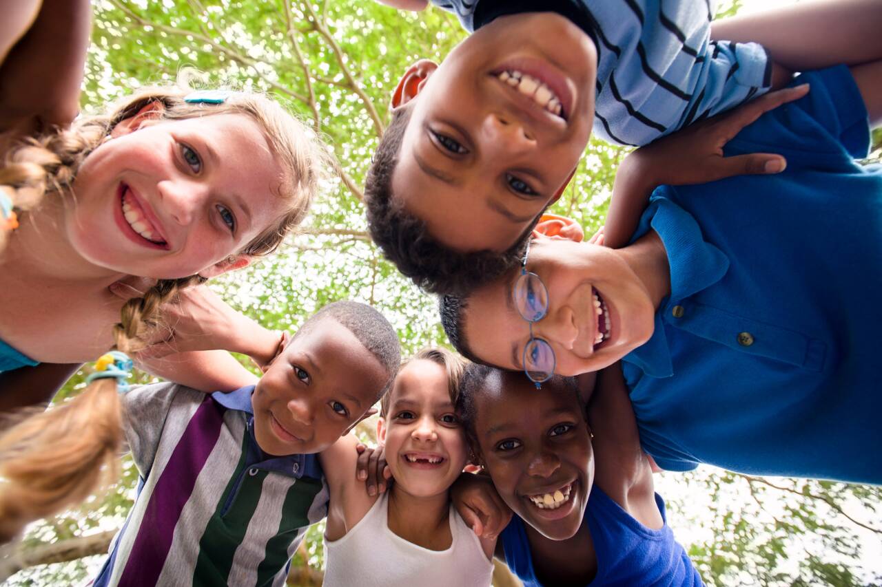 Crianças sorrindo em círculo ao ar livre