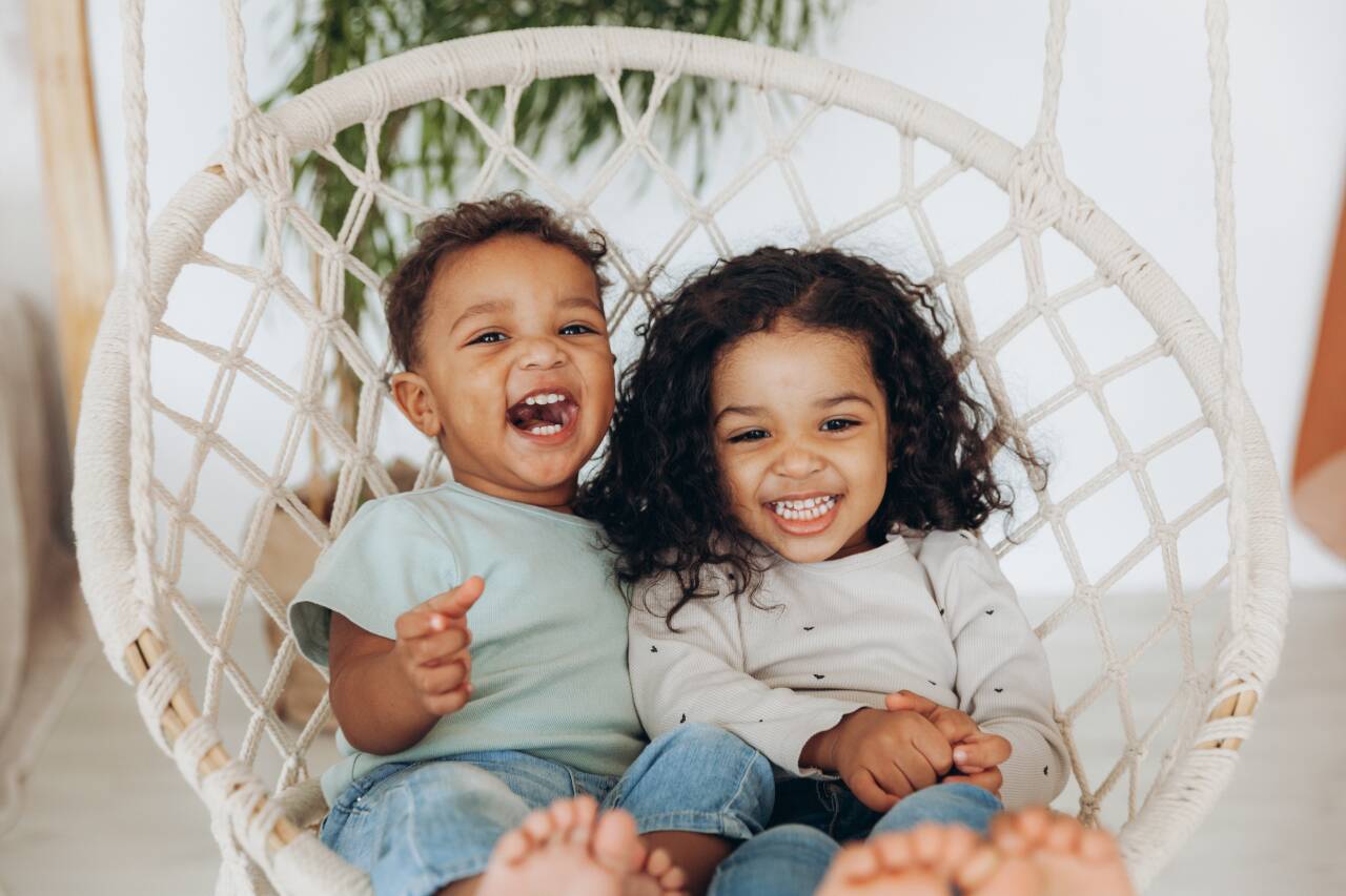 Crianças sorrindo em uma rede de descanso